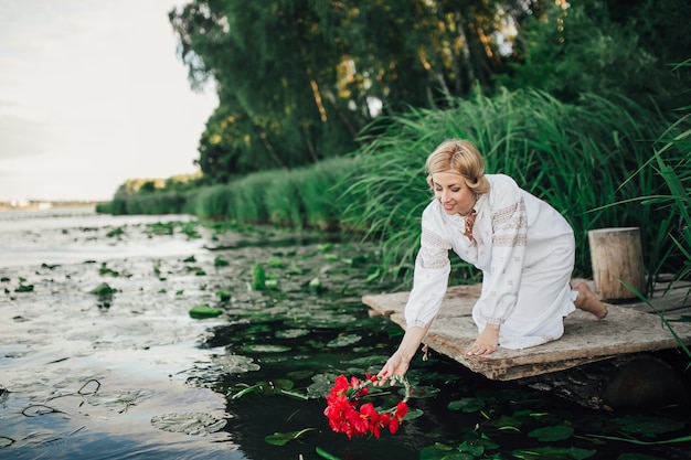 Zdjęcie blond ukranianka pochylająca się nad wodą