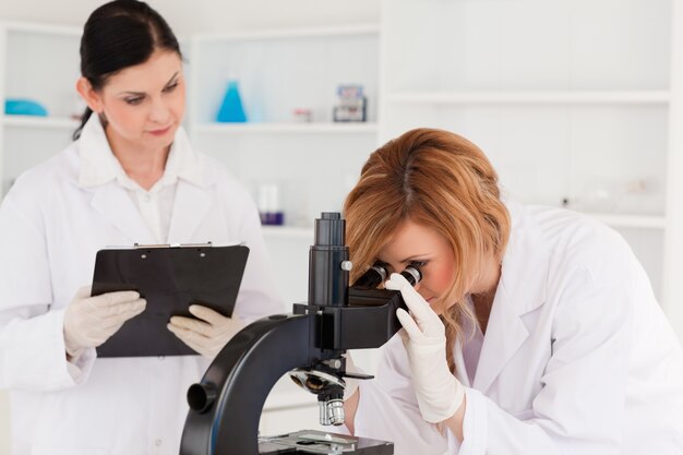 Zdjęcie blond włosach naukowiec i jej asystent prowadzący eksperyment