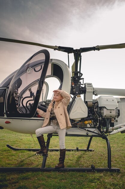 Blondynka animowana w pobliżu helikoptera patrząca w dal