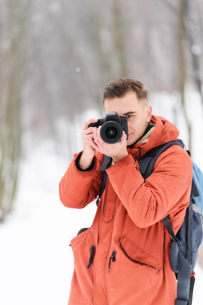 Blondynka fotografująca chłopca robiąca zdjęcie zimowych krajobrazów podczas spaceru po lesie