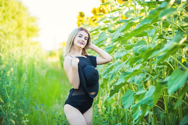 Blondynka młoda kobieta w czarnym stroju kąpielowym, pozowanie na zewnątrz