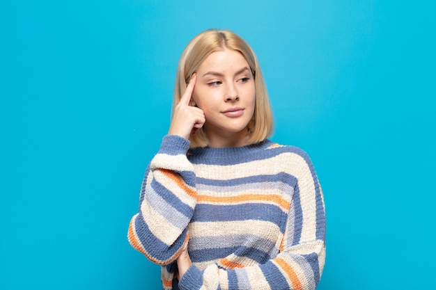 Blondynka o skoncentrowanym spojrzeniu, zastanawiająca się z wątpliwym wyrazem twarzy, patrząca w górę i w bok