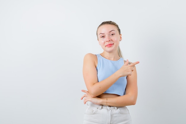 Blondynka Pokazuje Prawą Stronę Palcem Na Białym Tle