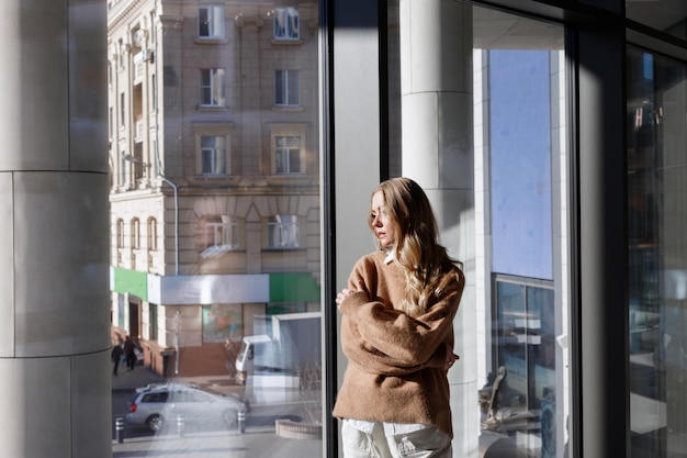 Blondynka pomyślała przy oknie z widokiem na miasto