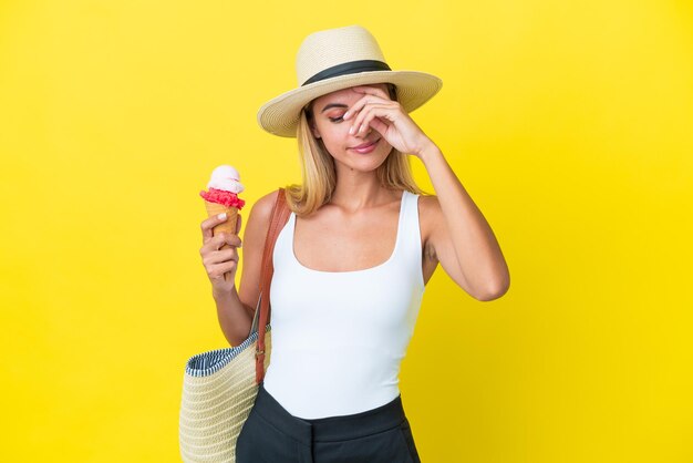 Blondynka Urugwajska dziewczyna latem trzymająca lody na żółtym tle śmiejąc się