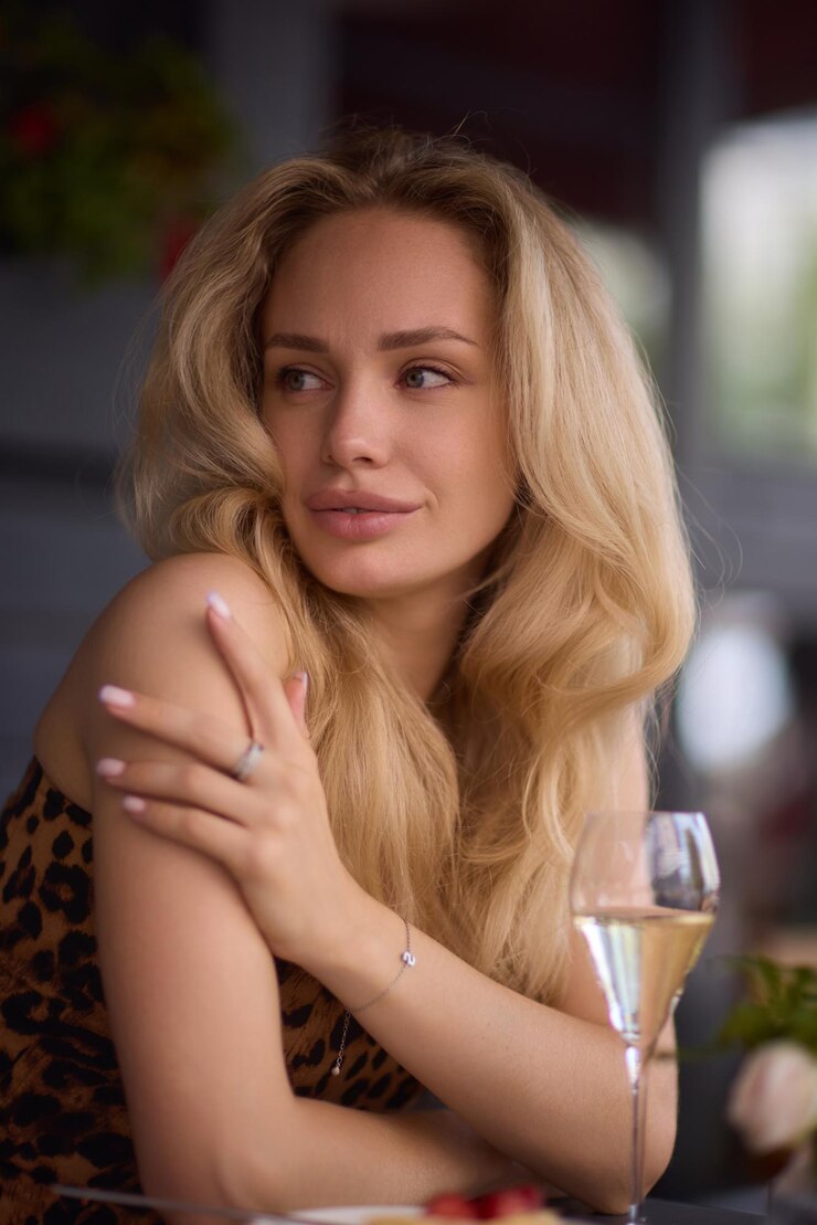 Zdjęcie blondynka w leopardowym topie siedzi w kawiarni na świeżym powietrzu ze stylowym tłem miasta