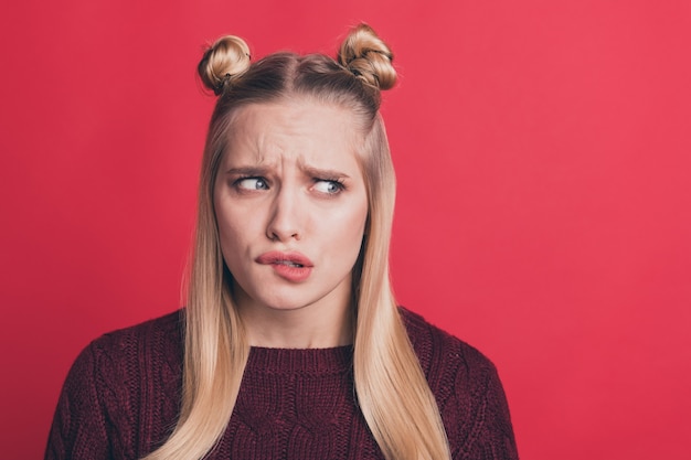 Zdjęcie blondynka z top-knots pozowanie na czerwonej ścianie