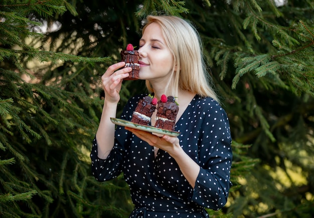 Blondynki kobieta je czekoladowego tort z jedlinowym drzewem