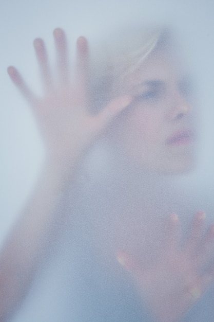 Zdjęcie blondynki kobiety macanie oszroniony szkło