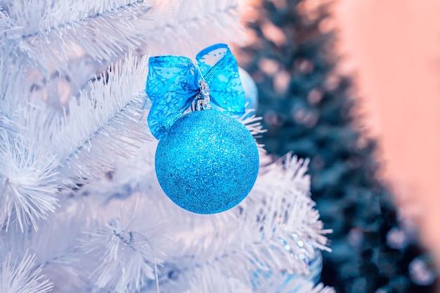 Blue Christmas ball wisi na białym sztucznym jodle