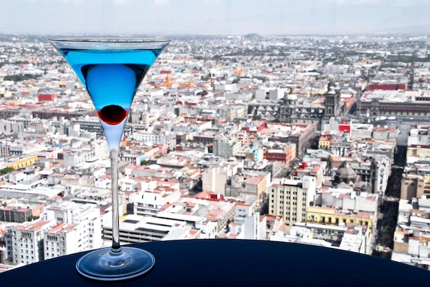 Blue curacao koktajl martini z wiśnią, tłem panoramicznym widokiem na miasto, napojem, Lifestyle