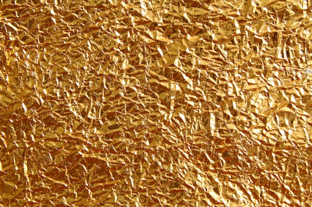 Zdjęcie błyszczącego metalu tekstury żółty złoty tło. metaliczny złoty wzór