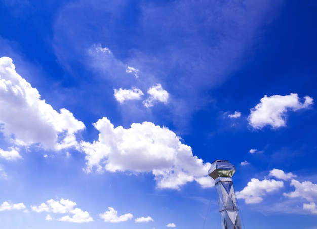 Zdjęcie błyszczący stalowy kominek i chmura na niebieskim niebie