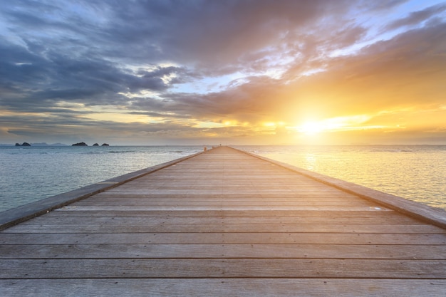 Boardwalk lub drewniany most morze przy zmierzch plażą