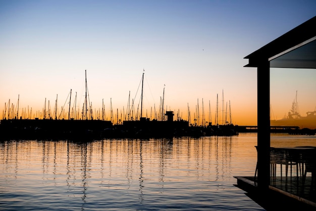 Boathouse siedzi w wodzie z zachodzącym za nim słońcem.