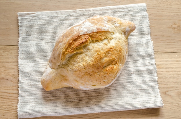 Bochenek białego chleba na drewnianym stole