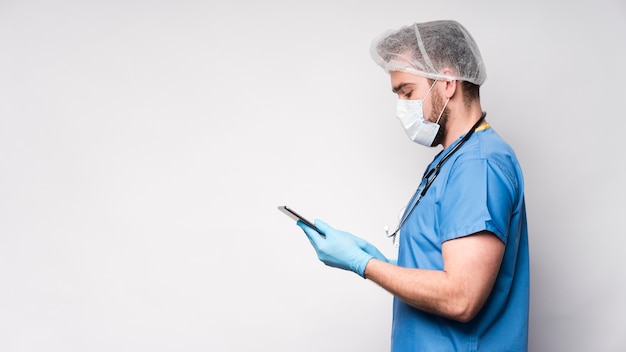 Zdjęcie bocznego widoku męska pielęgniarka wyszukuje pastylkę