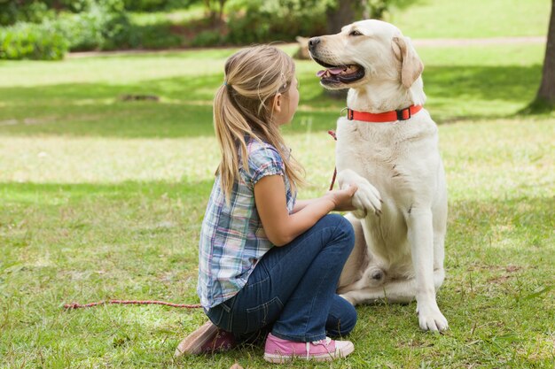 Boczny widok dziewczyna z zwierzę domowe psem przy parkiem