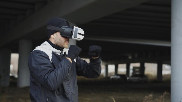 Bokser wojenny w zestawie słuchawkowym VR 360 uderza w wirtualną walkę w miejskiej lokalizacji