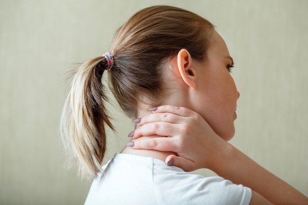 Ból barku szyi, kręgi szyjne. Kobieta trzyma ręcznie szyję z bólem, skurczem mięśnia szyjnego. Choroba układu mięśniowo-szkieletowego u młodej kobiety. Opieki zdrowotnej i koncepcji medycznej.