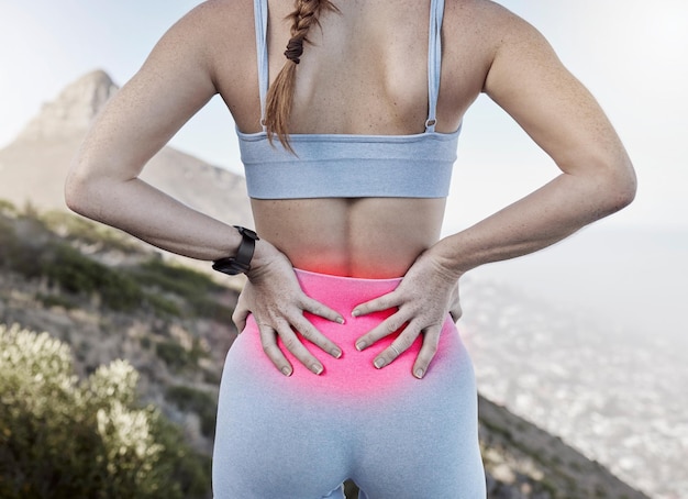 Ból w dole pleców uraz sportowy i kobieta trzymająca bolącą część ciała po treningu i treningu ze świecącą czerwoną odzieżą sportową Biegacz sportuje kobietę i sportowca na zewnątrz dla sprawności i ulgi