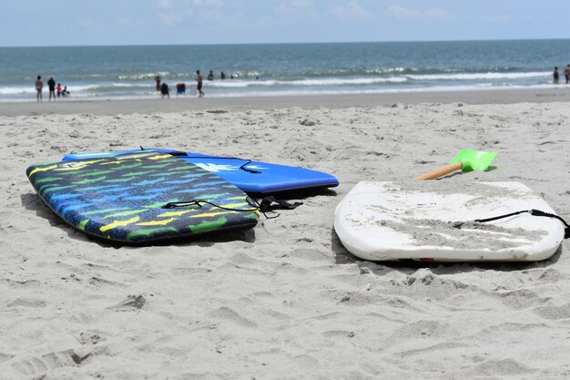 Zdjęcie boogie boards na piasku na plaży na tle nieba