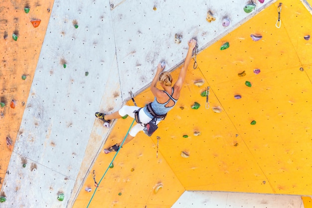 Bouldering, dziewczyna wspinająca się po ścianie