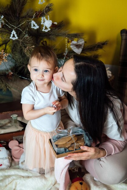 Boxing day i rozpakowywanie pudełek na prezenty świąteczne śliczna mała dziewczynka i mama rozpakowują prezent