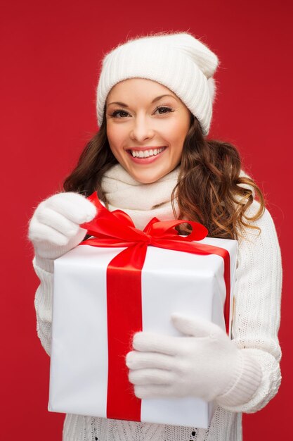 boże narodzenie, boże narodzenie, zima, koncepcja szczęścia - uśmiechnięta kobieta w białych ubraniach z pudełkiem na prezent