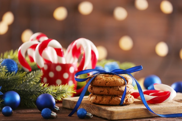 Boże Narodzenie Candy Canes w filiżance z świąteczną dekoracją na stole na jasnej powierzchni