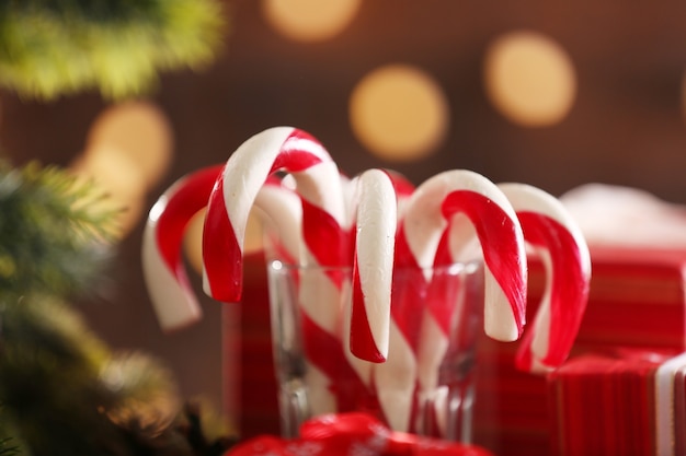 Boże Narodzenie Candy Canes w szkle z świąteczną dekoracją na stole na jasnym tle