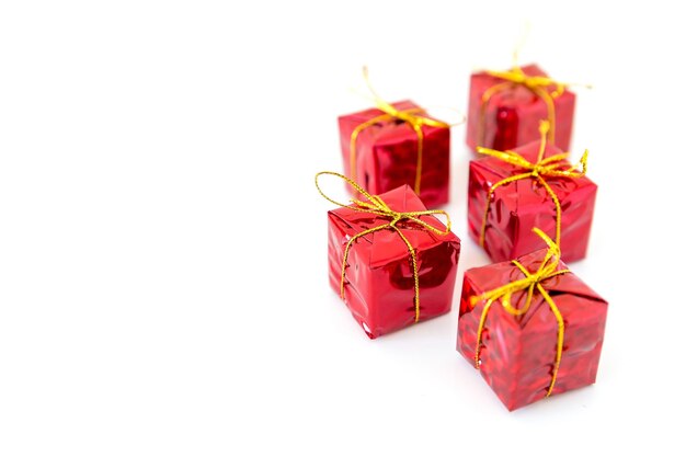Zdjęcie boże narodzenie czerwone błyszczące pudełka z prezentami wyizolowane na białym tle z przestrzenią dla tekstu