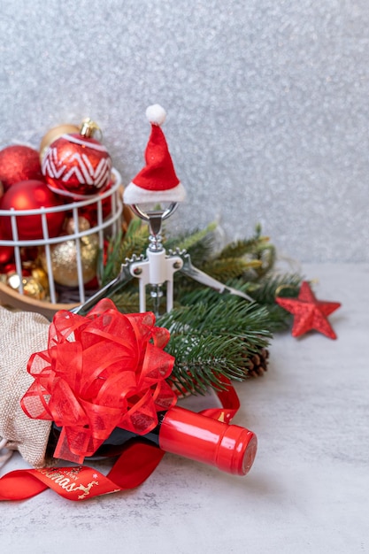 Boże Narodzenie Czerwone wino i otwieracz do wina z dekoracją kapelusza santa na tle stołu.