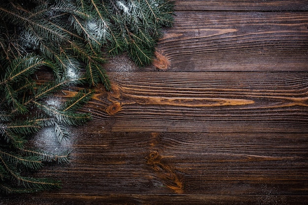 Boże Narodzenie drewniane tło ozdobione śnieżnym drzewem i prezentami z miejscem na kopię