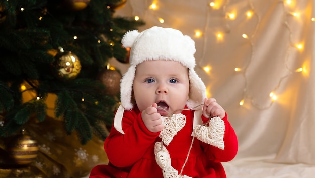 Boże Narodzenie dziecko patrząc w kamerę i trzymając wianek z sercami.