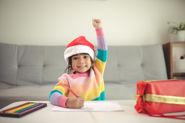 Boże Narodzenie Dziecko pisze list do Świętego Mikołaja, dziecko w Santa Hat pisze listę życzeń