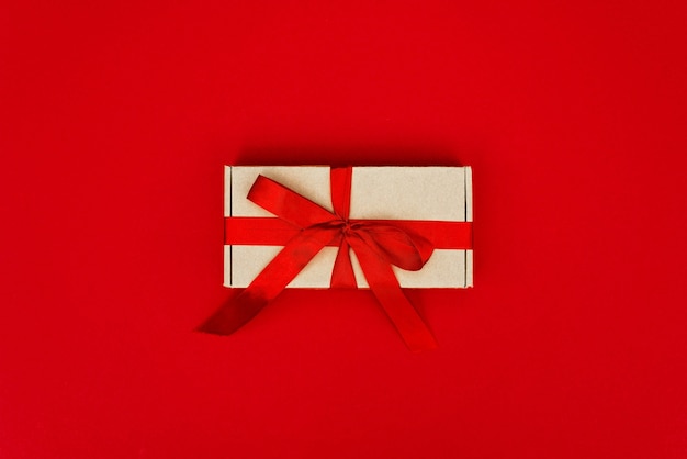 Boże Narodzenie pudełko ozdobione wstążką na białym tle na czerwono