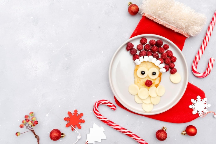 Zdjęcie boże narodzenie santa claus twarz w kształcie naleśnika ze słodkimi świeżymi malinowymi jagodami i serem na talerzu na szarym tle dla dzieci dziecko dzieci śniadanie obiadxmas jedzenie z noworocznymi dekoracjami kopia przestrzeń