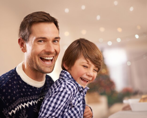 Zdjęcie boże narodzenie tata i portret zabawne dziecko w domu z bokeh wiązanie i rodzina bawiąc się razem na uroczystej uroczystości xmas twarz i dziecko z ojcem śmieje się na wakacjach dla miłości na imprezie