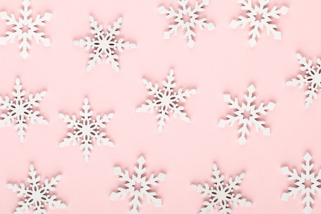 Zdjęcie boże narodzenie tło. białe dekoracje śnieżne na różowym tle.