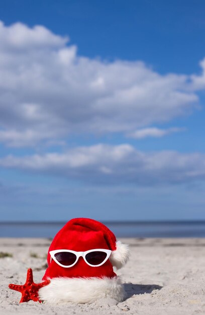 Zdjęcie boże narodzenie tło czapka świętego mikołaja na plaży