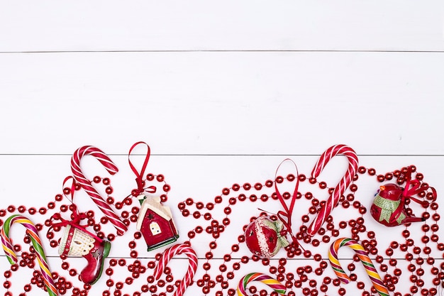 Boże Narodzenie tło czerwone świąteczne zabawki girlanda paski lizaki na białych tablicach