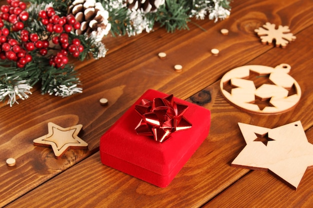 Boże Narodzenie tło. Drewniane tło z gałęzi choinki, szyszki i czerwone pudełko. Kartka noworoczna i świąteczna