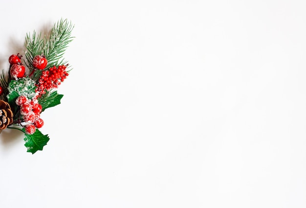 Boże Narodzenie tło, gałązka świerkowa z czerwonymi jagodami na białym tle, kopia przestrzeń