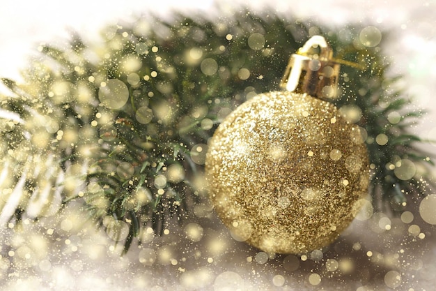 Boże Narodzenie tło z gałęzi i złotą bożonarodzeniową kulą