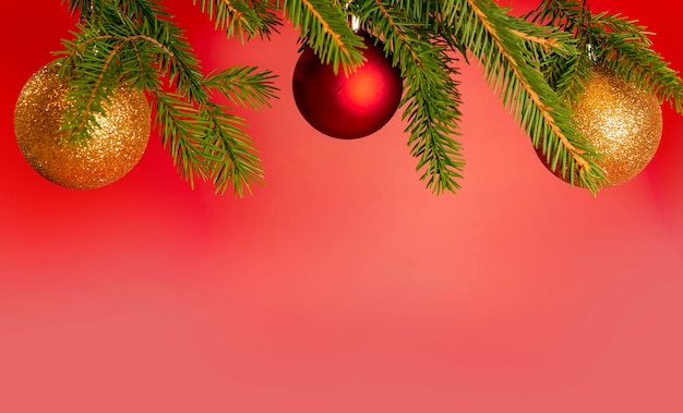 Boże Narodzenie tło z miejsca na kopię. Świątecznie udekorowane świerkowe gałęzie na czerwonym sztandarze. ..