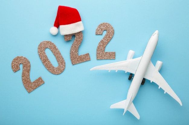 Boże Narodzenie tło z samolotem i napisem 2022 na niebieskim tle. Święta Bożego Narodzenia