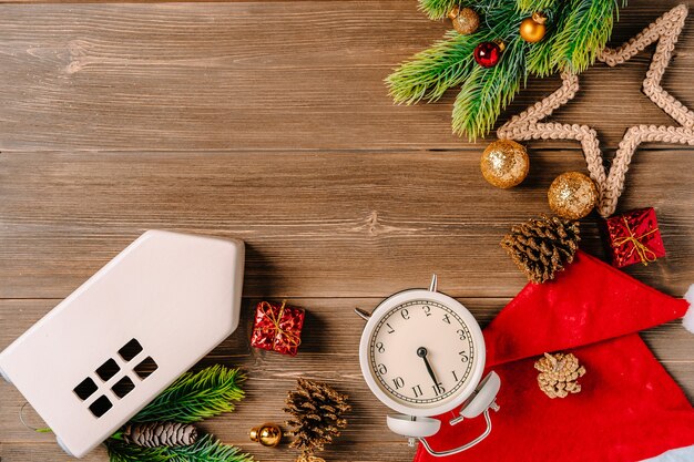 Boże Narodzenie tło z zegarem ozdoby i ceramiczny dom na drewnianym stole