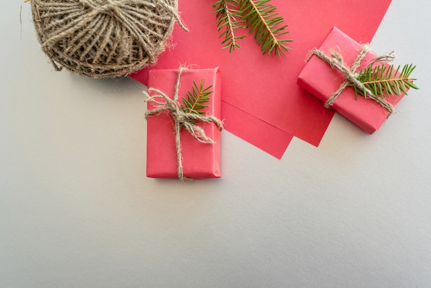Boże Narodzenie z pudełkami, sznurkami, papierem i ozdobami na czerwono. Przygotowanie do wakacji.