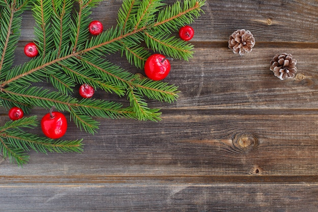Boże Narodzenie zielony świerk gałąź nowego roku drzewo z jabłkami czerwonego cukru śniegu, szyszki na rustykalnym drewnianym stole